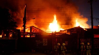 Bombeiros combatem incêndio em um armazém durante os distúrbios no Chile.