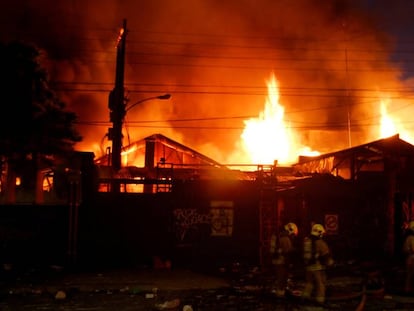 Bombeiros combatem incêndio em um armazém durante os distúrbios no Chile.