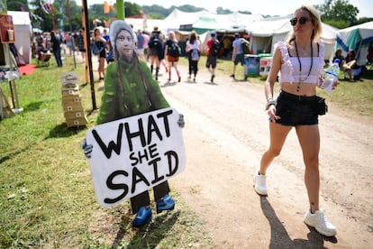 Una asistente camina frente a un cartel con la imagen de la activista por el clima Greta Thunberg, el 26 de junio de 2019.