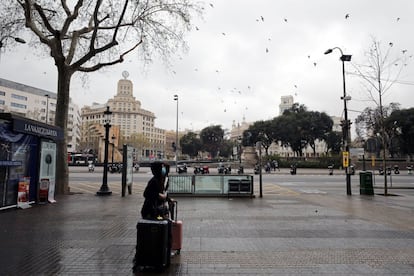 Una persona porta una máscara protectora mientras camina por la Plaza de Cataluña. Imagen tomada el 16 de marzo.