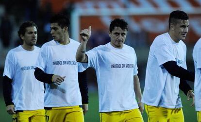 Jugadores del Atlético lucen una camiseta contra la violencia.