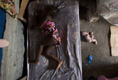 Naika Pierre, de dos años, duerme en una cama sobre el suelo sucio de la carpa donde vive con sus padres en uno de los campamentos provisionales que se levantaron tras el terremoto en Cite Soleil, en Puerto Príncipe. Cuando se produjo el seísmo en 2010, el edificio donde residían los padres de Naika sufrió graves daños y se vieron obligados a trasladarse. Cinco años más tarde, todavía están viviendo bajo lonas.