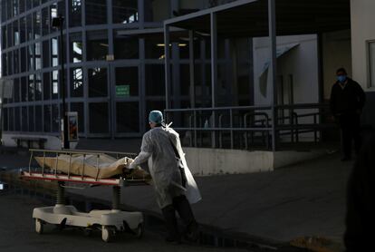 Un trabajador sanitario mueve el cuerpo de un fallecido por covid-19 en Ciudad Juárez.