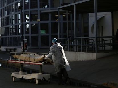 Un trabajador sanitario mueve el cuerpo de un fallecido por covid-19 en Ciudad Juárez.