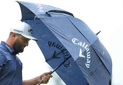 Rahm se protege de la lluvia durante la segunda jornada del PGA Championship.