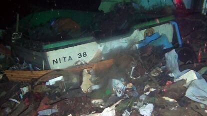 Una embarcación hundida rodeada de basura.