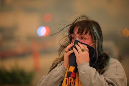 Una mujer observa el incendio desde la carretrea. 