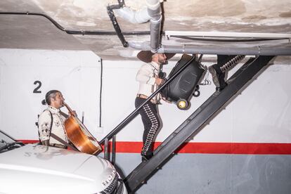 Los mariachis suben por una escalerilla para entrar en una actuación.