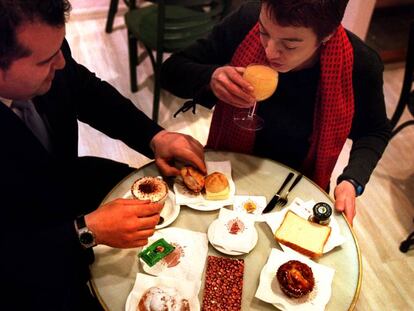 Una pareja desayuna con varios productos de boller&iacute;a