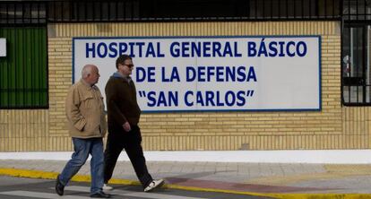 Dos hombres pasan frente a la entrada del hospital San Carlos.