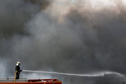 Un bombero sofocando el incendio, el 14 de mayo, un día después de iniciarse.