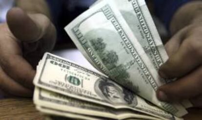 Un trabajador cuenta dólares estadounidenses en un banco de El Cairo (Egipto) hoy, lunes 31 de diciembre de 2012.