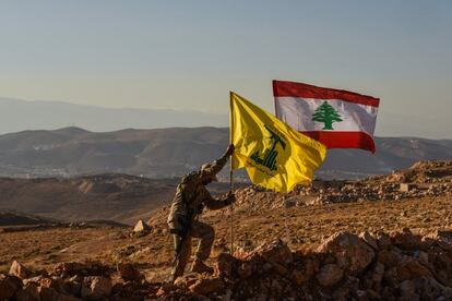 Un combatiente de Hezbolá planta las banderas libanesa y de la milicia tras expulsar a Al Qaeda de los arrabales de la localidad libanesa de Arsal en julio de 2017