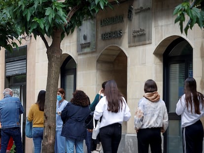 People in San Sebastián line up to be tested for the coronavirus after around 50 positive cases were detected among students returning from Mallorca.