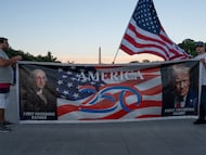 Un grupo de personas sostiene una pancarta con imágenes de George Washington, el primer presidente de EE UU, y de Trump, en Washington.
