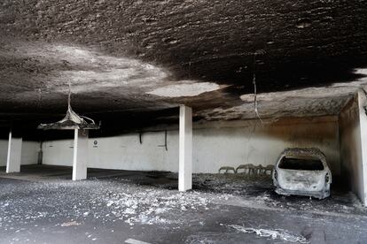 Vista de uno de los coches incendiados, en un parking, este domingo. 