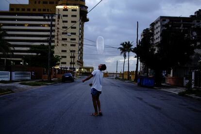 Arturo Pérez, de 14 años, juega en la calle con un condón en La Habana (Cuba)