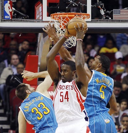 Patrick Patterson, de los Houston Rockets, atrapa el balón ante Ryan Anderson y Dominic McGuire de los New Orleans Hornets