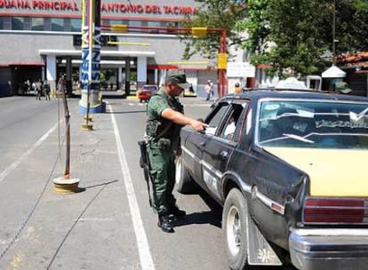 Un miembro de la Guardia Nacional venezolana ordena a un taxista que abra el maletero antes de pasar la frontera en San Antonio, Venezuela