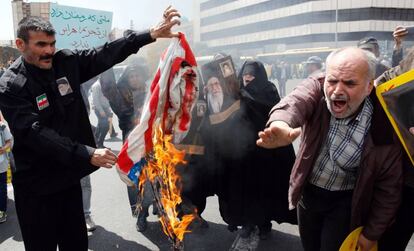 Manifestantes iraníes queman banderas estadounidenses, el pasado viernes en Teherán.