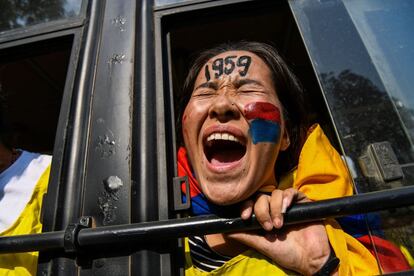 Una joven tibetana exiliada grita consignas desde un autobús de la policía mientras protesta contra una visita de líderes chinos a la India, en Nueva Delhi.