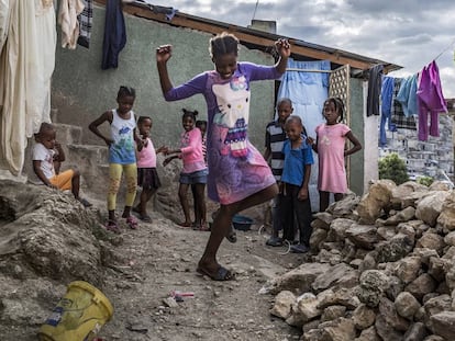 Una niña del barrio de Jalousie baila entre las chabolas ante la mirada divertida de sus amigos.