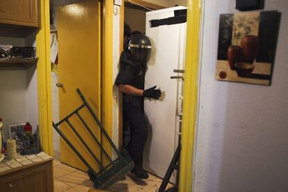 Un policía se abre paso apartando el frigorífico que bloqueaba el acceso a la vivienda. El desalojo ha sido ejecutado pese a la resistencia de decenas de activistas de Plataforma de Afectados por la Hipoteca.
