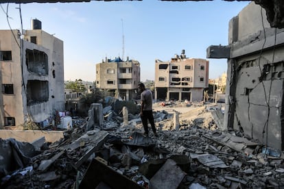Un hombre busca entre los escombros de los edificios destruidos por los ataques israelíes, este lunes en Jan Yunis.