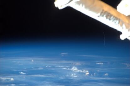 Imagen tomada desde la ISS por el astronauta Paolo Nespoli, el pasado 16 de febrero, pocos minutos después del lanzamiento del carguero <i>Johannes Kepler</i>, en la que se aprecia el rastro de gases del cohete Ariane-5 justo debajo del brazo articulado de la estación (arriba  a la izquierda).