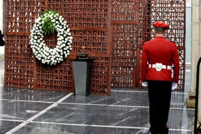 Un <i>ertzaina,</i> ante el monumento en recuerdo a las víctimas del terrorismo levantado a la entrada del Parlamento.