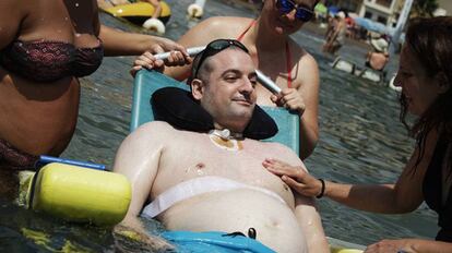 Sergio Romero, inmovilizado por una polineuropatía, se baña en Mazarrón, ayudado por la Ambulancia del Deseo.