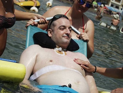 Sergio Romero, inmovilizado por una polineuropatía, se baña en Mazarrón, ayudado por la Ambulancia del Deseo.