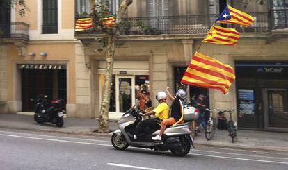 Dos joves porten banderes catalanes durant la Diada del 2012.