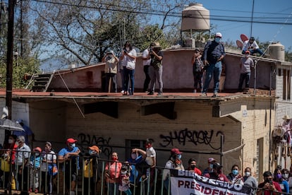 Seguidores del presidente López Obrador  escuchan atentos su mensaje, a las afueras del convento.