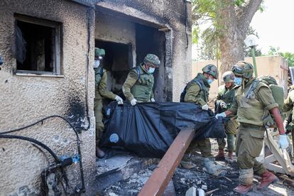 Varios soldados sacan un cadáver de una vivienda de Kfar Aza.