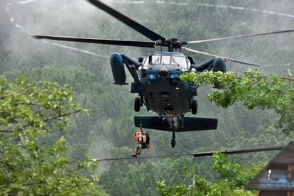 Unos 12.000 efectivos de las Fuerzas niponas de Auto Defensa (Ejército), policías y bomberos continúan con las tareas de búsqueda y rescate. En la foto, miembros del ejército rescatan a un residente aislado debido a las inundaciones en Asakura, el 7 de julio de 2017.