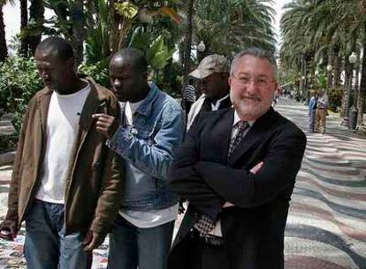 Bernat Soria, a la derecha, junto a tres inmigrantes en la Explanada de Alicante.