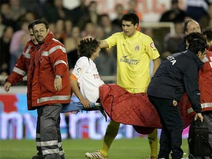 Riquelme saluda a Aimar mientras éste abandona el campo en camilla.