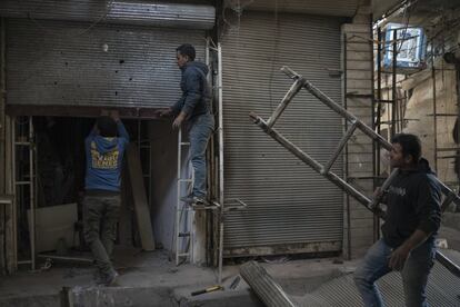 Trabajadores reparan la puerta de un comercio en la Ciudad Vieja de Mosul.