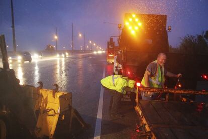 Miembros del Departamento de Transporte de Alabama trabajan para bloquear una parte inundada de la autopista 98.