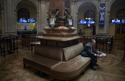 Un inversor lee la prensa en el Palacio de la Bolsa de Madrid