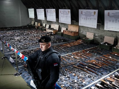 A Serbian police officer stands in front of weapons confiscated in the latest government disarmament action at a police depot near Smederevo, some 40km south of the capital Belgrade, on May 14, 2023.