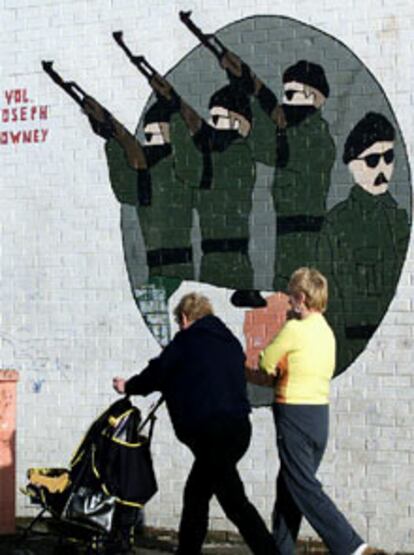 Dos mujeres pasan ante una pintada de apoyo al IRA en Belfast.