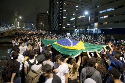 Students lift a Brazilian flag during Monday night&#039;s protest in S&atilde;o Paulo.