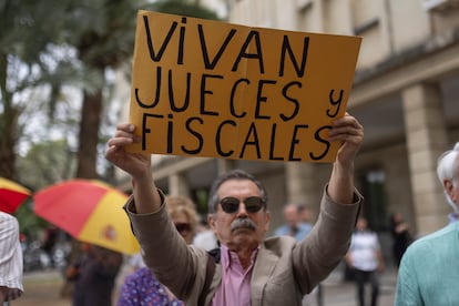 Un ciudadano muestra un cartel a favor de los jueves y fiscales, este miércoles, en el exterior del Palacio de Justicia de Sevilla.