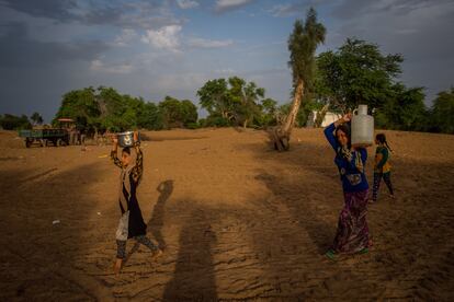 Unas mujeres transportan agua en un campo de refugiados cerca de Hamidiyeh, en el suroeste de Irán, en una imagen de abril de 2019.