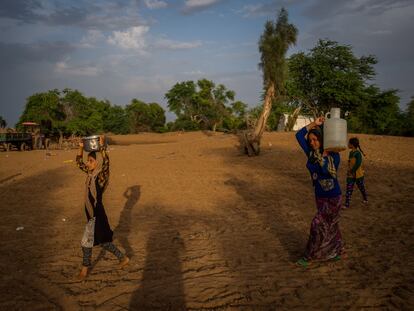 Unas mujeres transportan agua en un campo de refugiados cerca de Hamidiyeh, en el suroeste de Irán, en una imagen de abril de 2019.