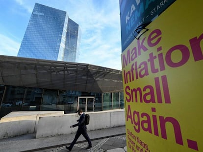 A man walks past an pre-election banner reading