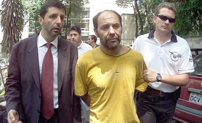 O líder dos sequestradores do publicitário Washington Olivetto, o chileno Maurício Hernandez Norambuena (c), é levado preso por policiais para ser apresentado na Delegacia Antissequestro (DEAS), em São Paulo, no dia 4 de fevereiro de 2002.