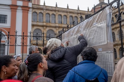 Personas revisan las listas afuera de un centro de votación en Bogotá.
